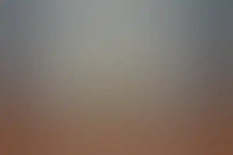 Photograph shows Georges Seurat’s large painting "A Sunday on La Grande Jatte—1884" hanging on a blue-gray wall between two open doorways to other galleries wearing a flat, wide, sharp-cornered white frame.