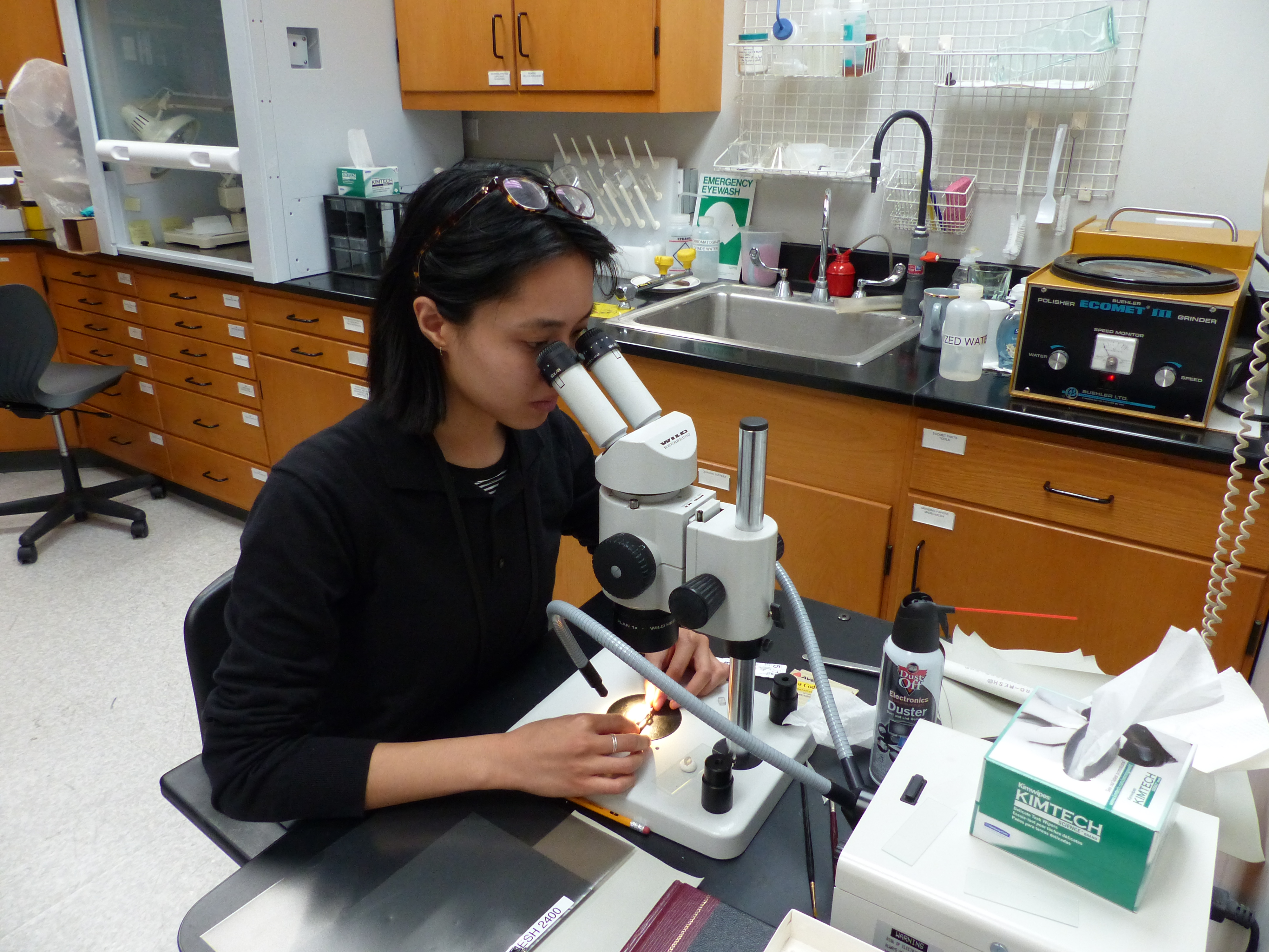 Intern Amanda Wong examining a cross section of paint under a microscope