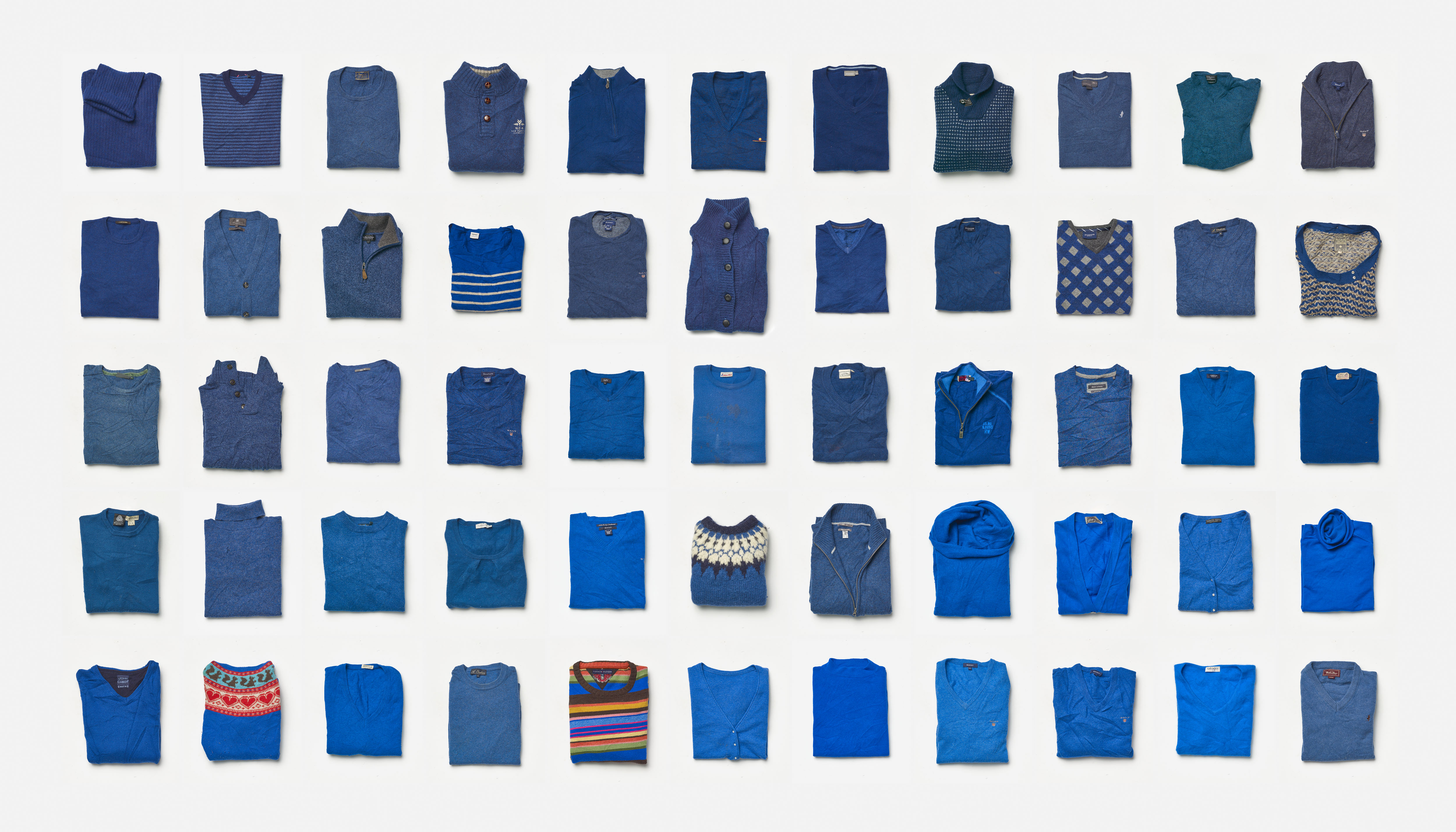 A photo of a grid of sorted blue wool sweaters.