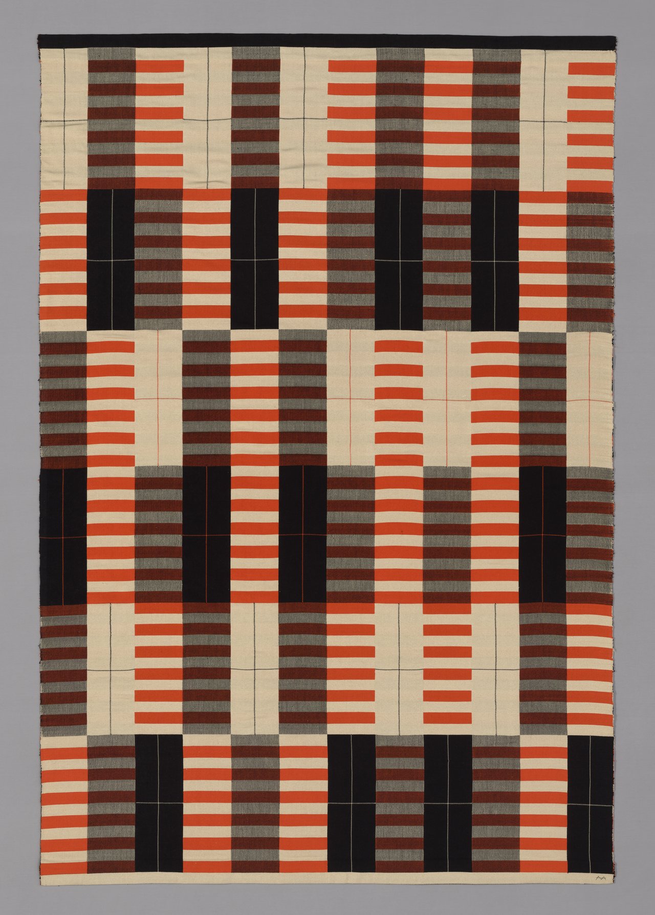 Weaving with a pattern of alternating rectangles in black, white, gray, and striped orange.