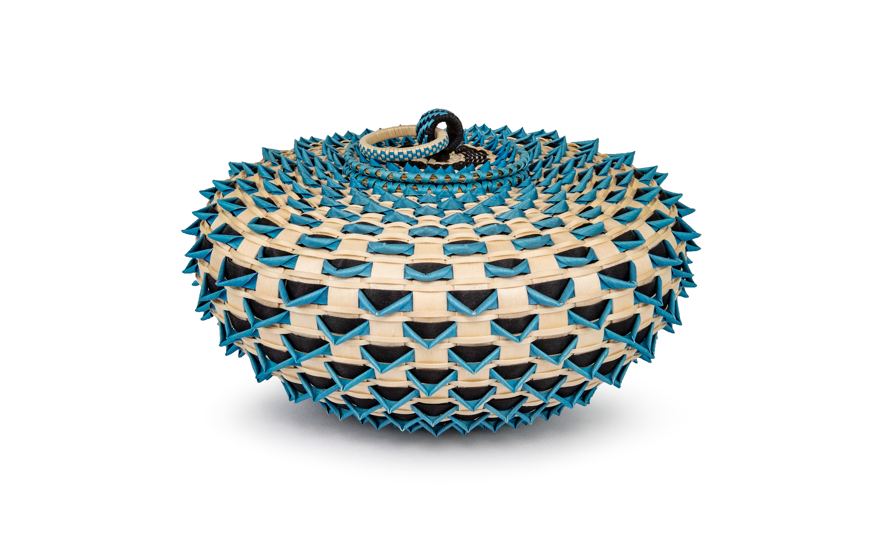 A blue, black, and blond wooden squat-shaped basket. Small blue and black triangular elements protrude at regular intervals. The ringed handle sits hinged along the top.