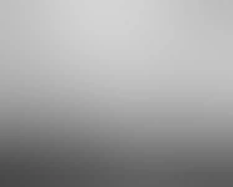 Black-and-white photograph taken at an angle of a wide gallery space featuring Seurat's "La Grande Jatte" in a slim white frame.