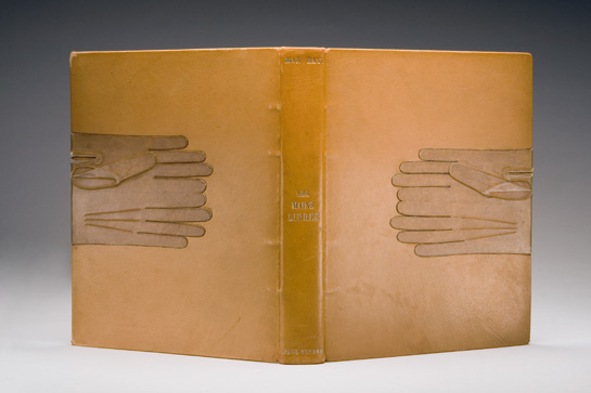 Tan leather cover of a book with matching leather gloves where you would hold a book.