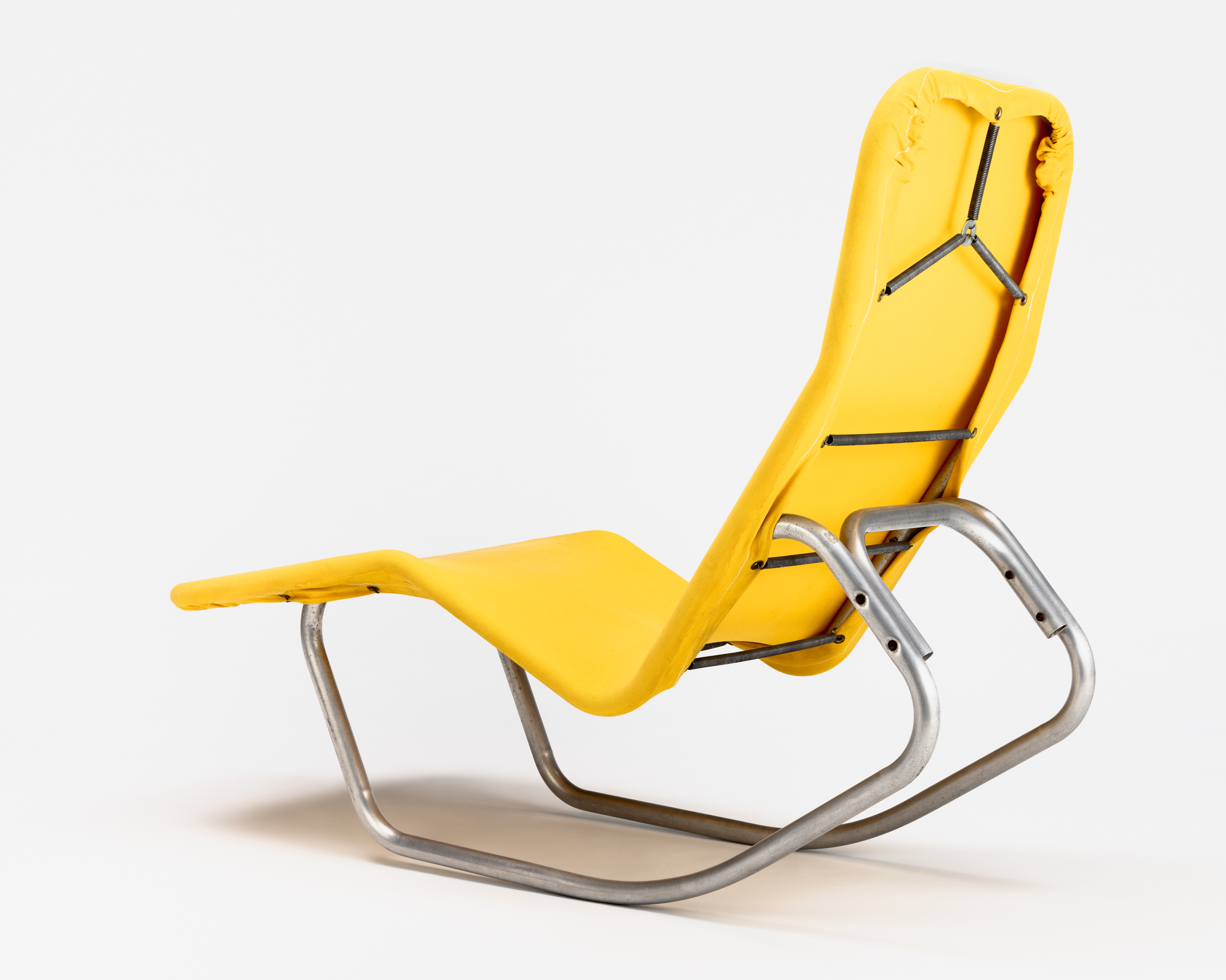 Back view of a lounge chair in bright yellow fabric on a metal frame