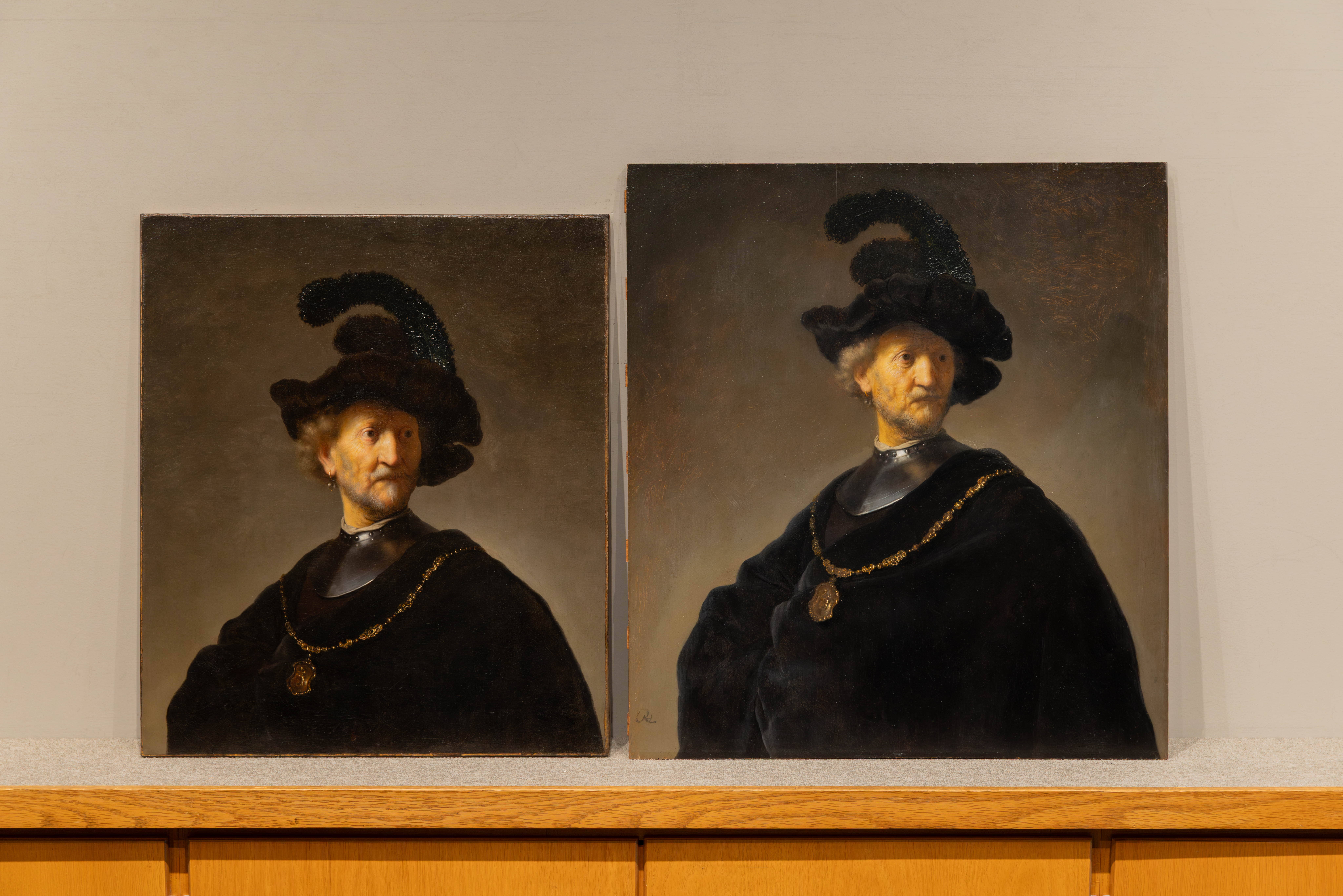 Two paintings of seemingly identical subjects sit side by side. In each a light-skinned older man with blond hair, beard, and mustache wears a deep-black cape and feathered hat, silver gorget, and wide gold necklace with a large pendant. The painting on the left is shorter, showing less of the subject's torso.