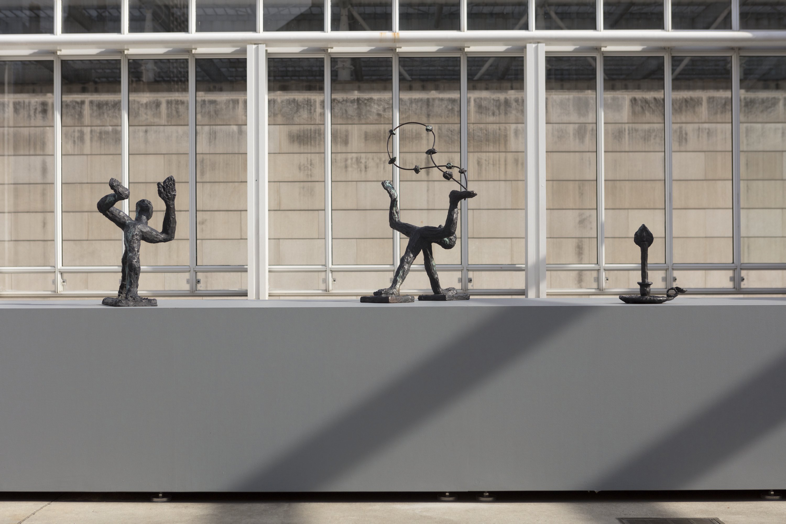 A close up view of bronze sculptures on a gray pedestal.