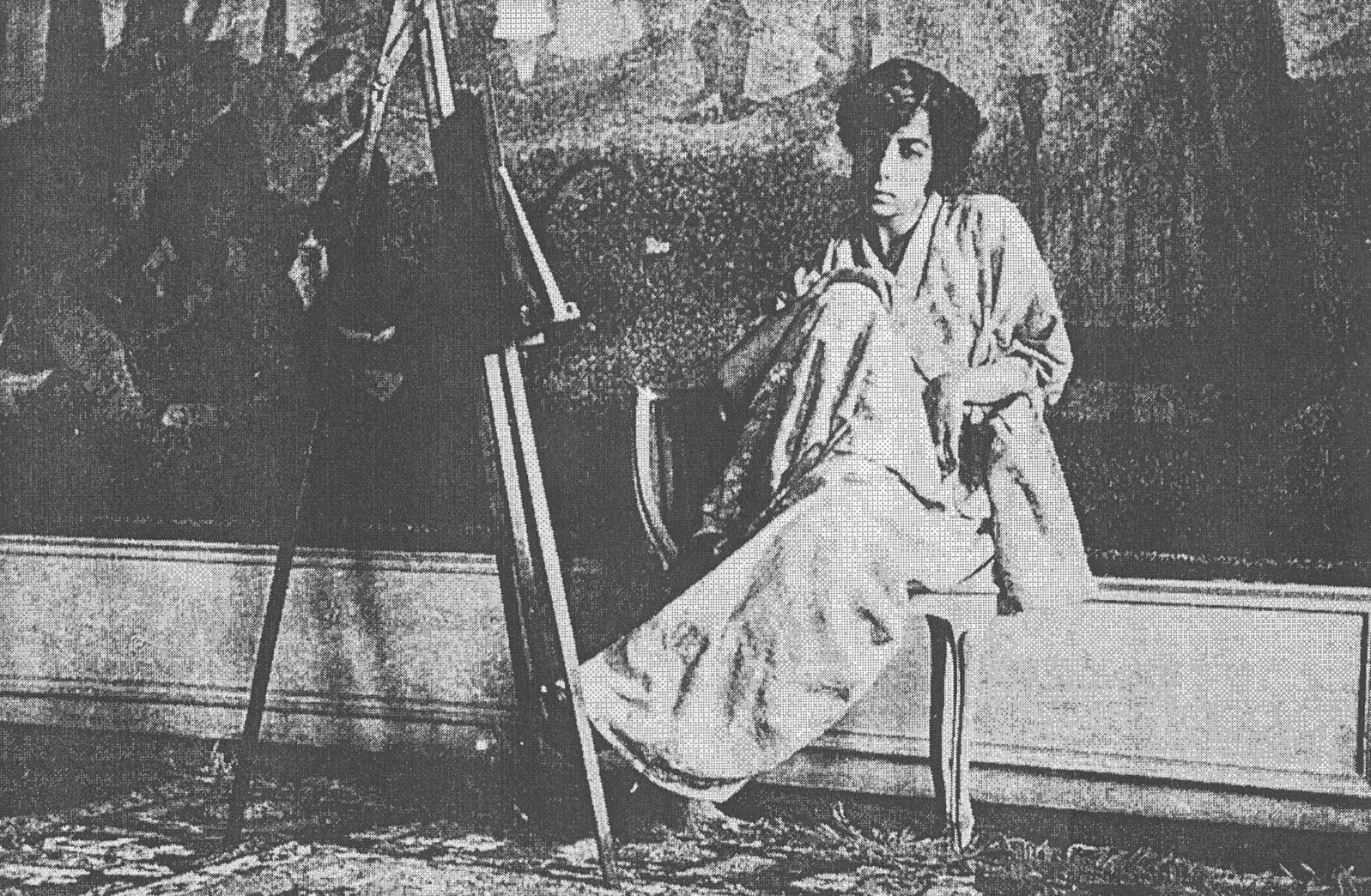 In a black-and-white photograph, a young woman in light-colored clothes sits placidly before the bottom portion of Seurat's "La Grande Jatte."