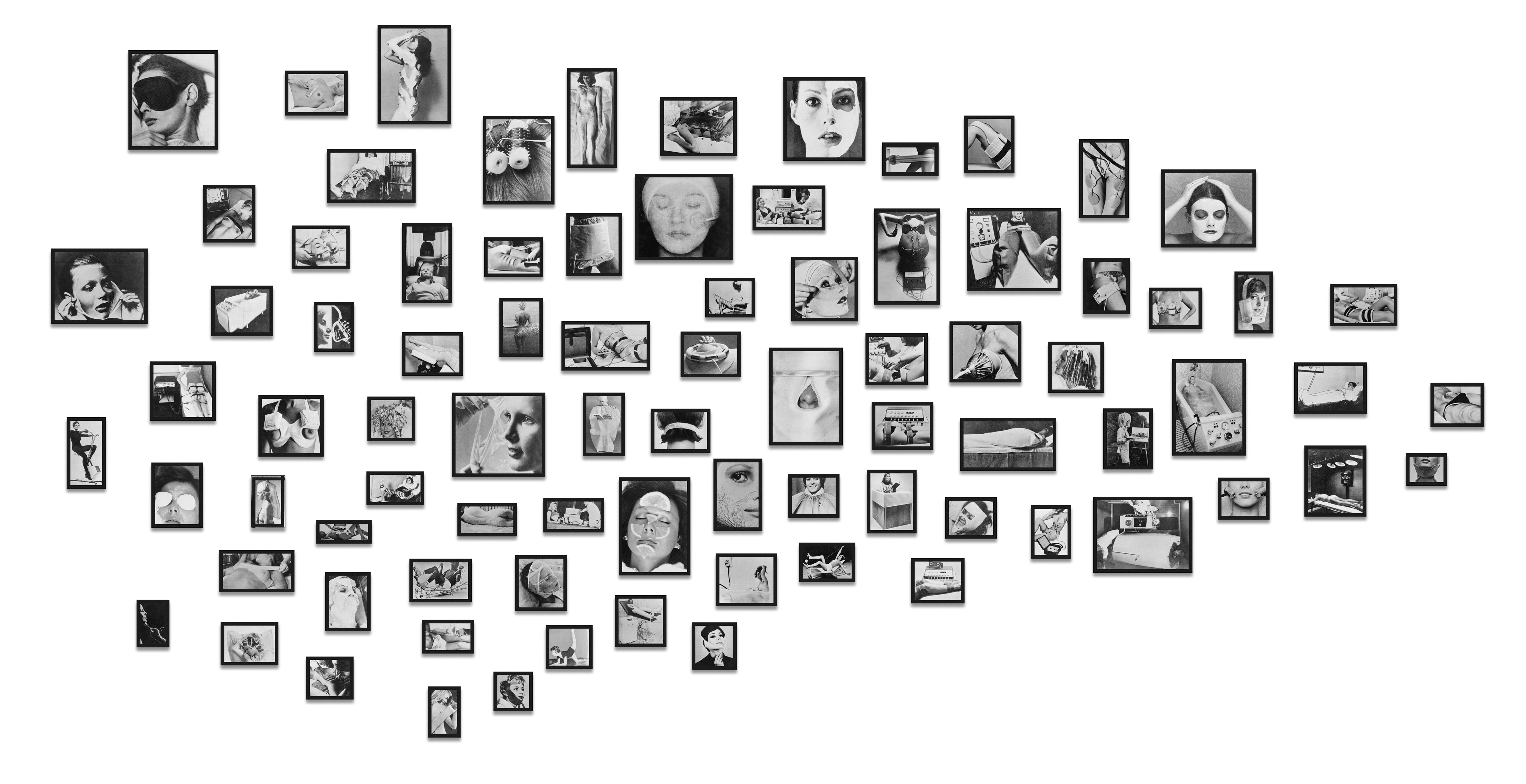 A black-and-white photograph shows a cloud-shaped cluster of many small rectangular framed photos on a white wall; at left a few portraits appear, at center the densest group shows close-ups of eyes and faces, and at right more images of hands, objects, and profiles.