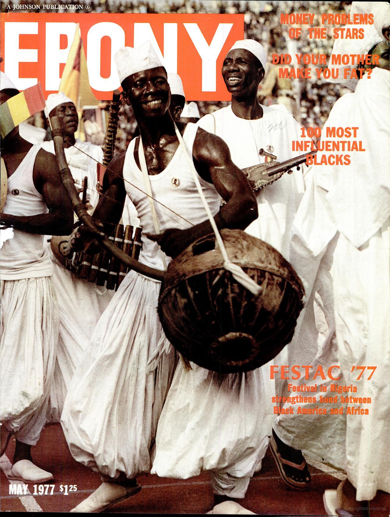Cover of Ebony magazine, May 1977 issue. The full-color photograph shows a group of men in traditional white garments and hats performing in a parade at FESTAC '77, an international festival celebrating Black and African culture, held in Nigeria. The central figure, a smiling drummer, carries a large round drum with a strap across his chest. The background is filled with additional performers and a large crowd. The magazine’s red masthead is partially visible behind the performers. Cover lines include “100 Most Influential Blacks” and “FESTAC '77: Festival in Nigeria strengthens bond between Black America and Africa.”