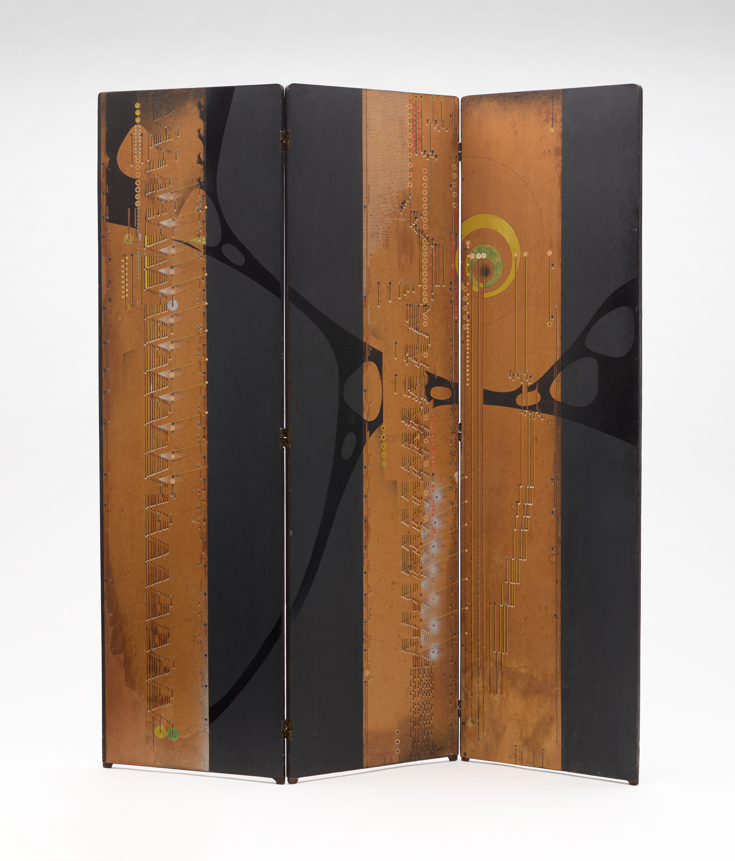 A three-panel folding screen. Each panel is divided vertically between a brown portion and flat black. On the brown parts, there are various small decorative elements—cuts, circles, lines. A  irregular web-like mark in black connects all three panels.