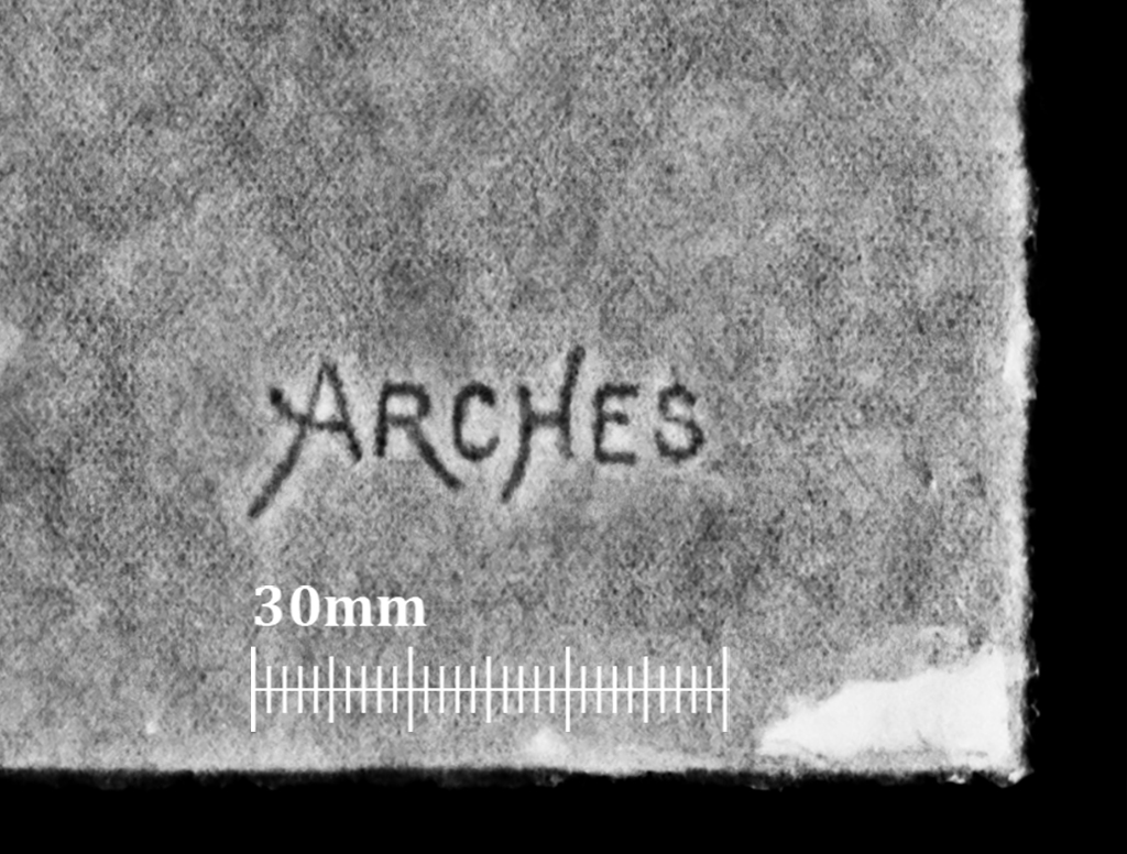 A gray, textured surface fills the frame. Near the center-right, the word “ARCHES” appears in small, dark letters. Along the lower left edge, a white measurement scale labeled “30mm” with evenly spaced tick marks runs horizontally, and the lower right edge shows a small, irregular white patch.