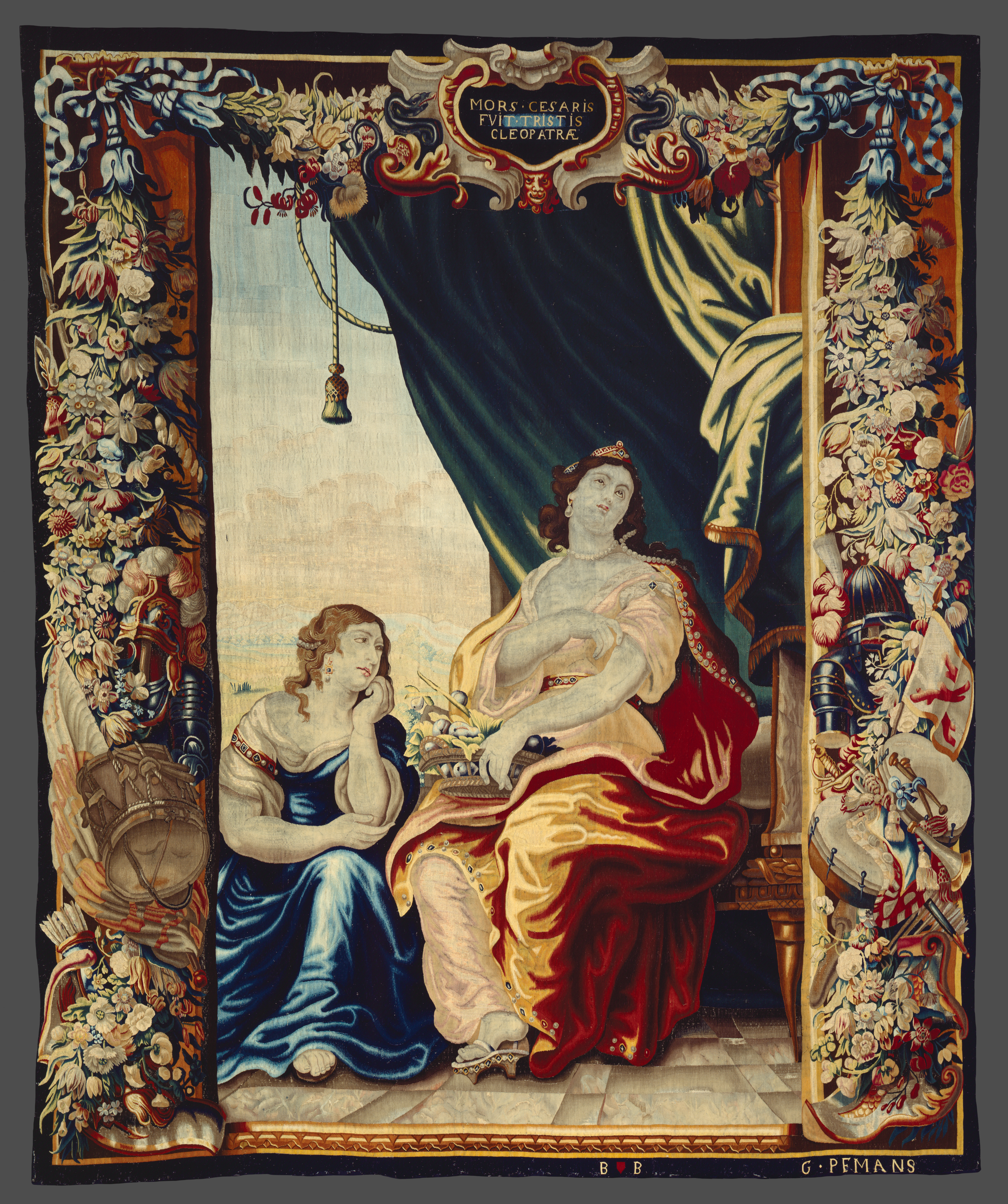 A large tapestry with an ornate border featuring two women with lamenting upward gazes.