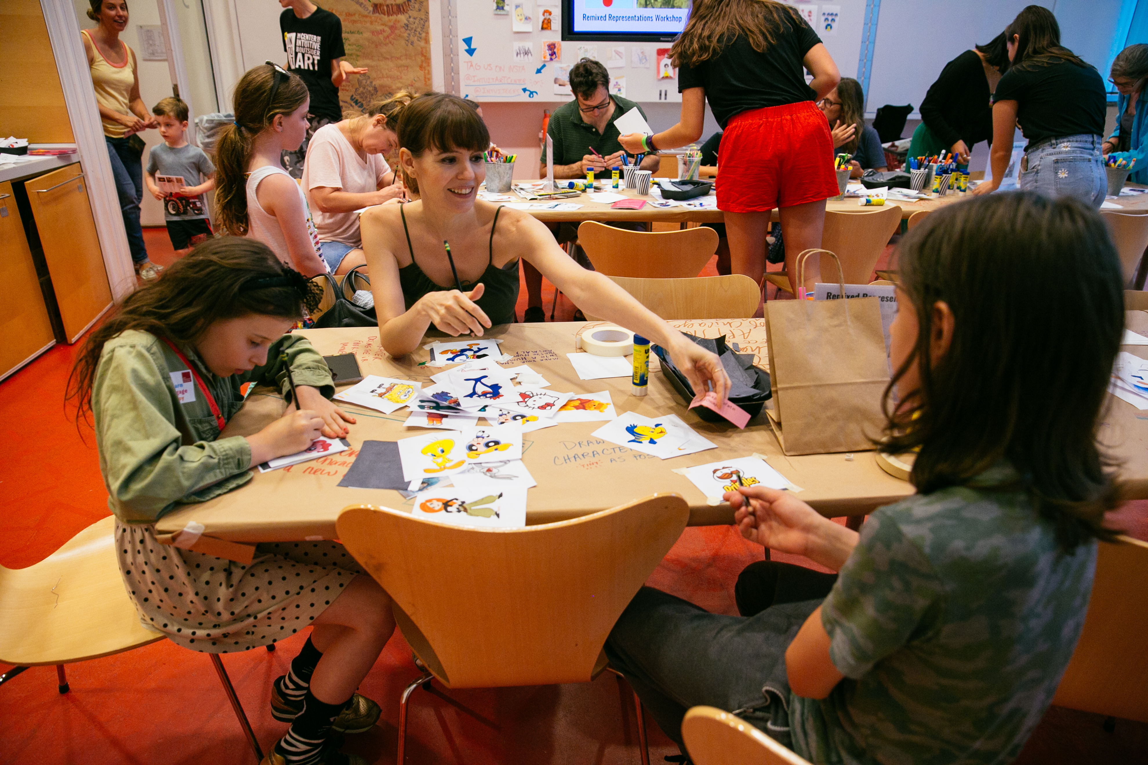 Adults and kids drawing cartoon characters during an activity at Block Party 2019