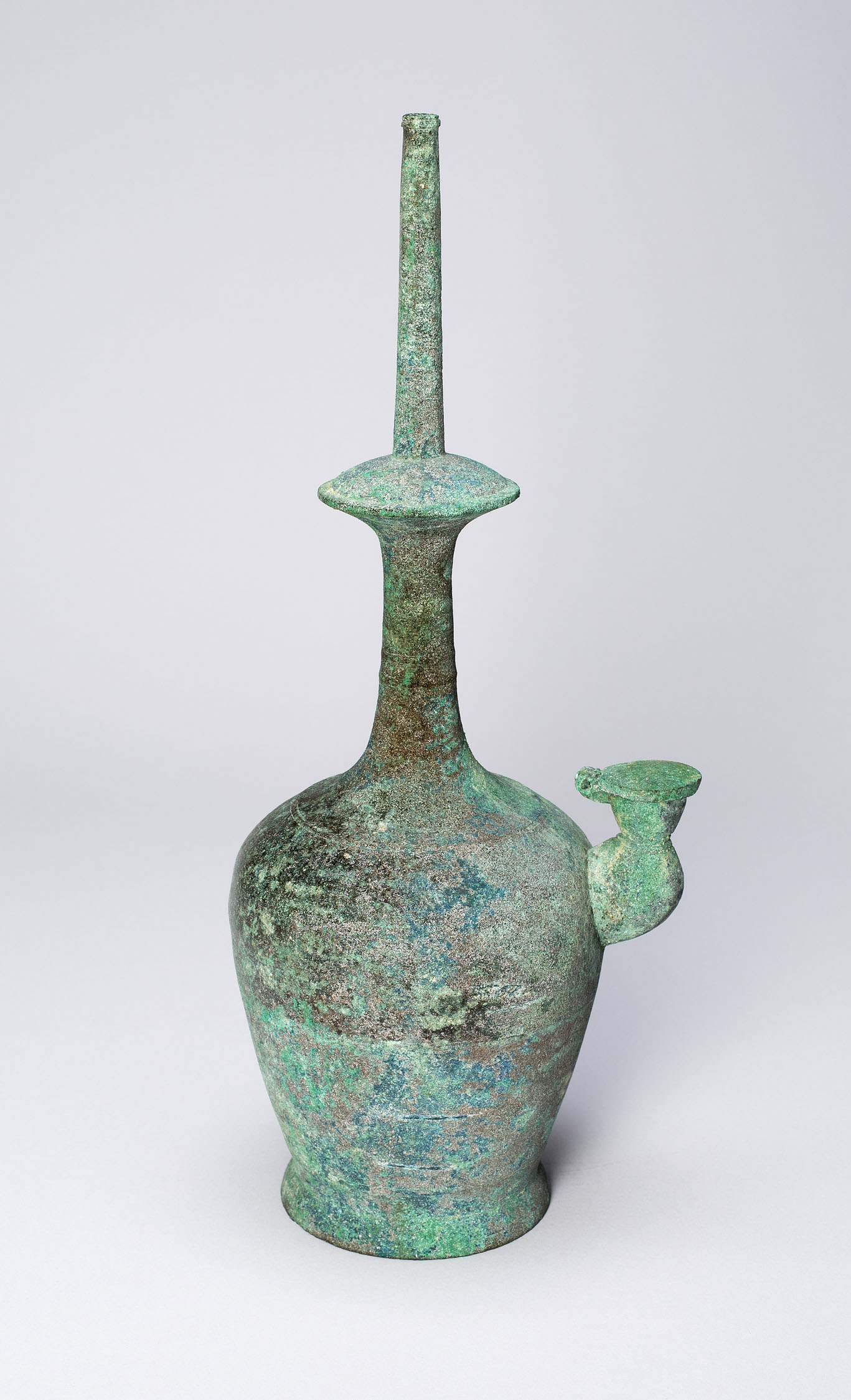 Tall and narrow green bottle with a rounded base.